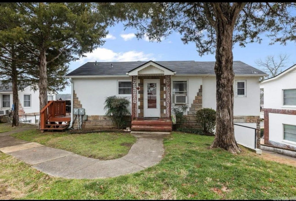 view of front of property with a front yard and cooling unit