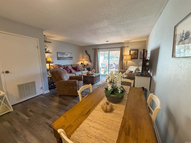 dining space featuring a textured ceiling and dark wood-type flooring