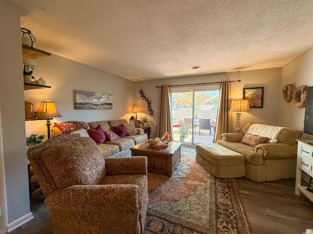 living room with a textured ceiling and dark hardwood / wood-style flooring