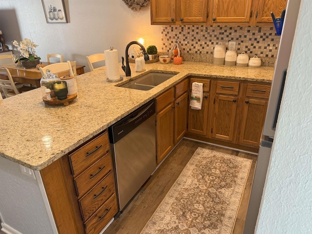 kitchen featuring a kitchen breakfast bar, kitchen peninsula, stainless steel dishwasher, and sink