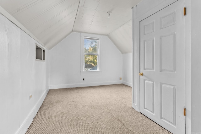 additional living space with light carpet and vaulted ceiling