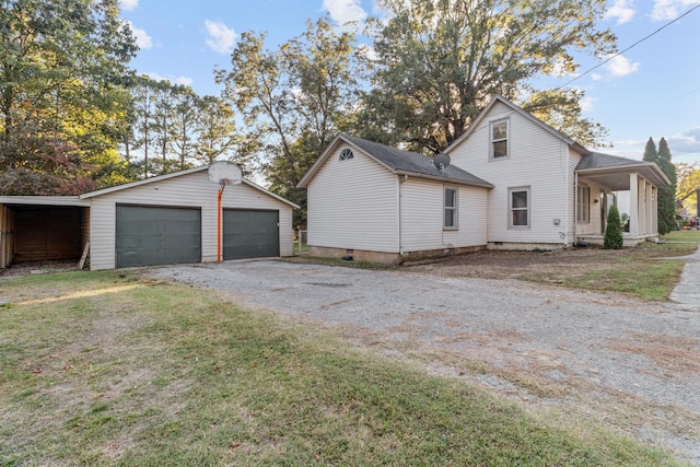 view of property exterior featuring a carport, an outdoor structure, a lawn, and a garage