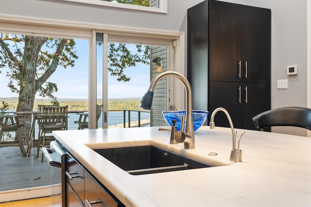 kitchen featuring sink, a water view, and light wood-type flooring