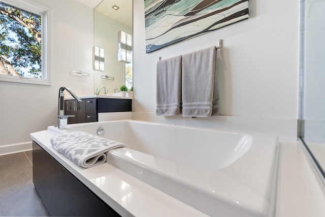 bathroom featuring vanity, a tub, and tile patterned floors