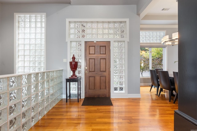 foyer entrance with a notable chandelier and light wood-type flooring