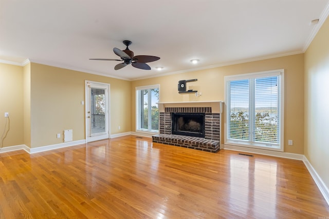 unfurnished living room featuring crown molding, hardwood / wood-style floors, a fireplace, and ceiling fan