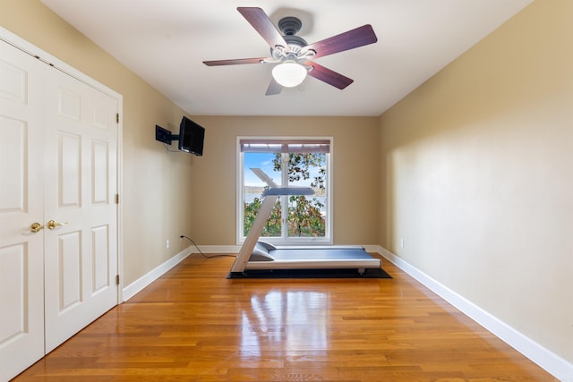 workout room featuring ceiling fan and light wood-type flooring