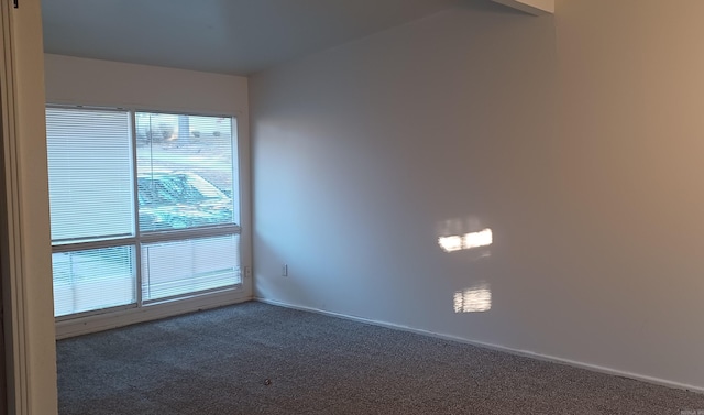 unfurnished room featuring dark carpet