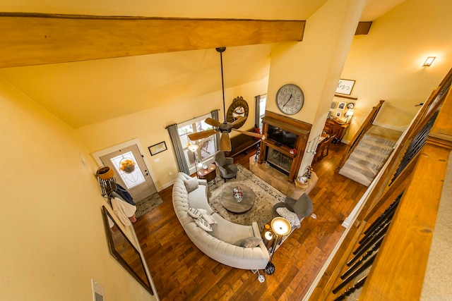 living room featuring lofted ceiling, a tiled fireplace, and wood-type flooring