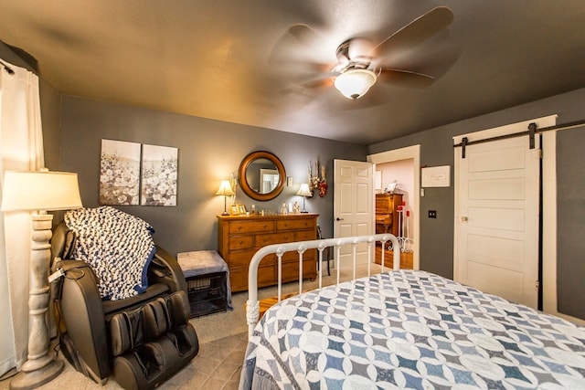 bedroom with ceiling fan and a barn door