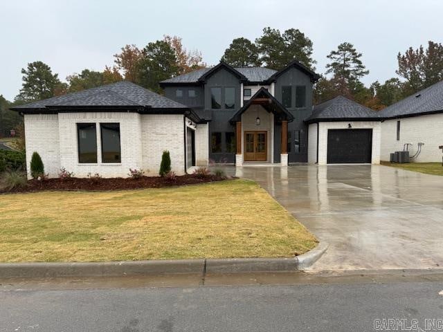 view of front of property featuring a front yard, central AC, and a garage