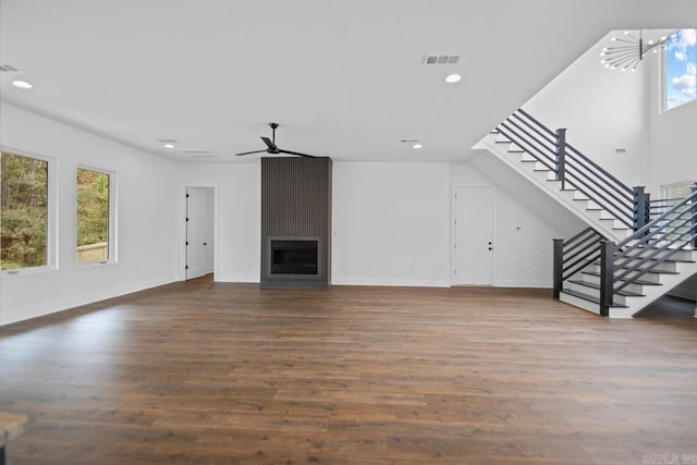 unfurnished living room featuring hardwood / wood-style flooring, a large fireplace, and plenty of natural light