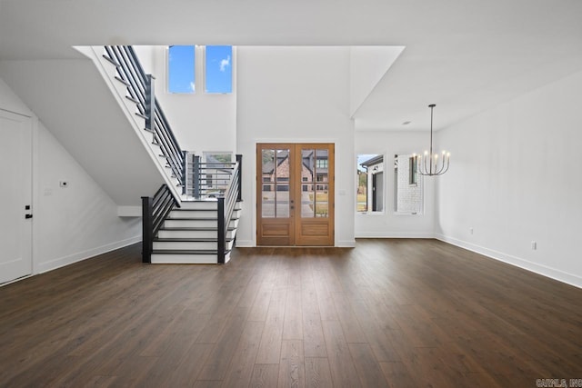 entrance foyer featuring a chandelier, dark hardwood / wood-style floors, a healthy amount of sunlight, and french doors