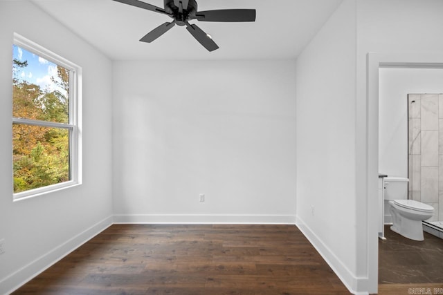 spare room featuring ceiling fan, a healthy amount of sunlight, and dark hardwood / wood-style flooring