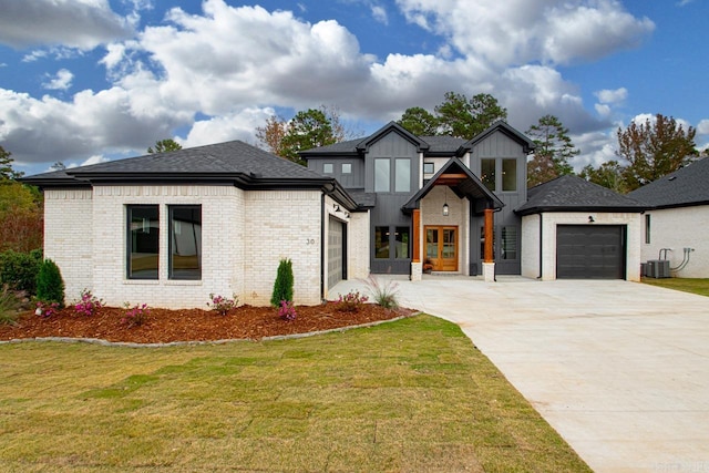 modern farmhouse style home featuring a front yard, cooling unit, and a garage