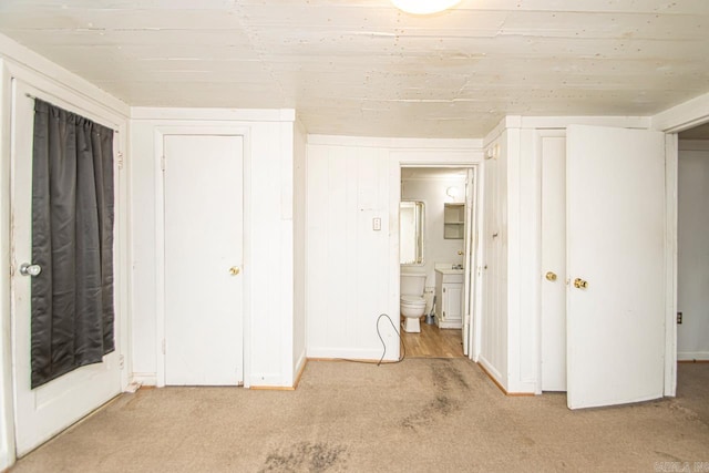 unfurnished bedroom featuring carpet floors and ensuite bathroom