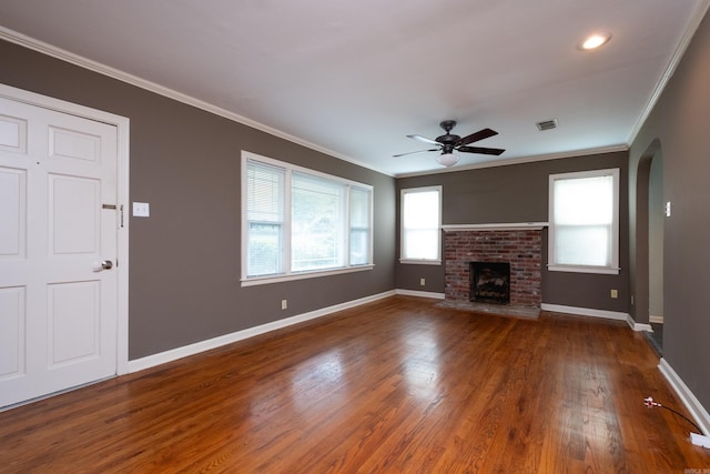 unfurnished living room featuring ornamental molding, dark hardwood / wood-style floors, and a brick fireplace