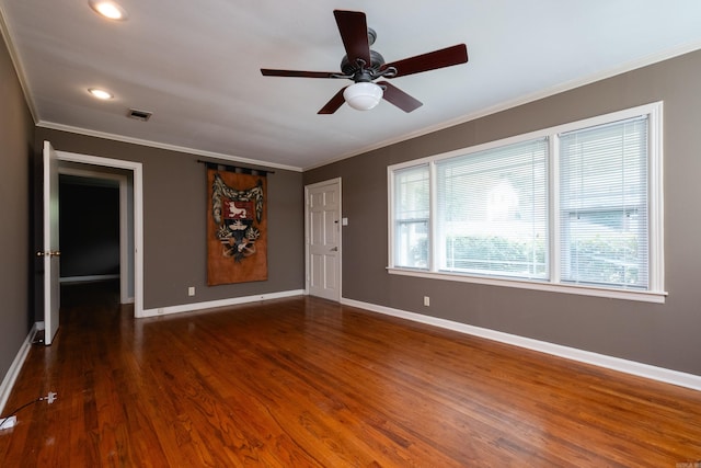 spare room featuring dark hardwood / wood-style flooring, crown molding, and a wealth of natural light