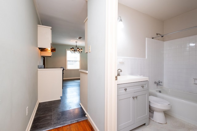 full bathroom featuring hardwood / wood-style flooring, toilet, tiled shower / bath combo, vanity, and a chandelier