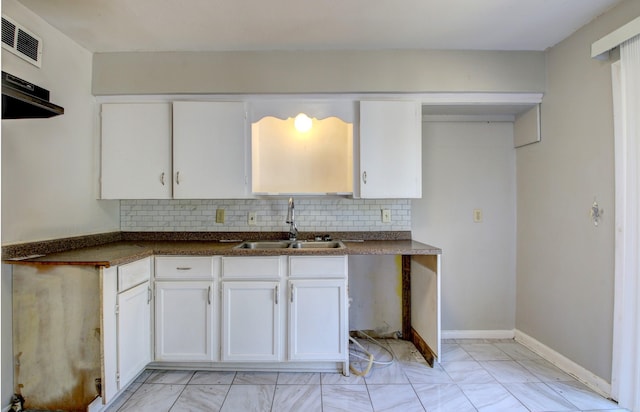 kitchen with white cabinetry, tasteful backsplash, and sink