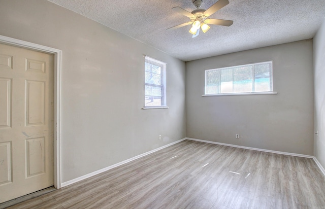 empty room featuring light hardwood / wood-style floors, a textured ceiling, and ceiling fan