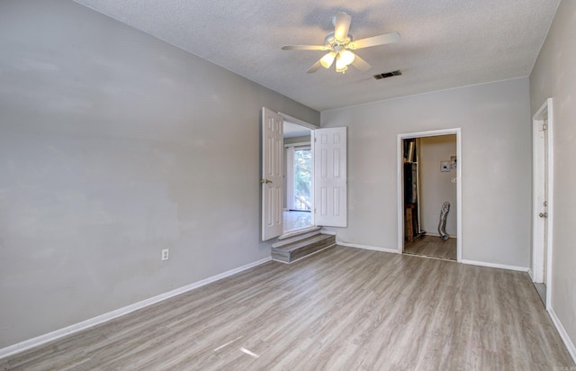 interior space with ceiling fan, a textured ceiling, and light hardwood / wood-style flooring