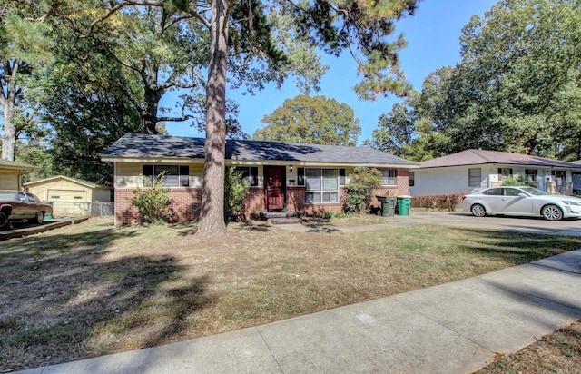 single story home featuring an outbuilding, a front lawn, and a garage