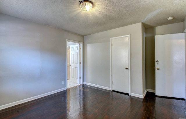 unfurnished bedroom with a textured ceiling, a closet, and dark hardwood / wood-style flooring