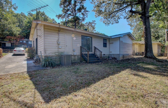 rear view of house featuring a yard and central air condition unit