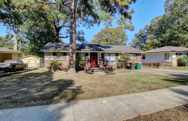 ranch-style house featuring an outdoor structure, a garage, a front lawn, and a porch