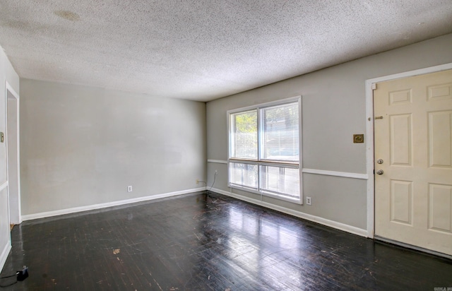 foyer entrance featuring a textured ceiling and dark wood-type flooring