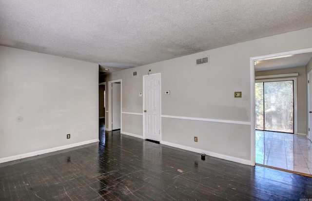 unfurnished room featuring a textured ceiling and dark wood-type flooring