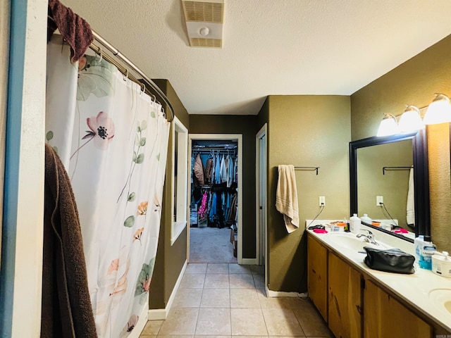 bathroom with vanity, shower / bathtub combination with curtain, a textured ceiling, and tile patterned floors