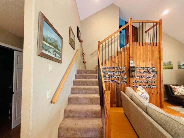 stairway with lofted ceiling and wood-type flooring