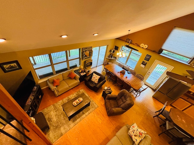 living room with a wealth of natural light, hardwood / wood-style floors, and an inviting chandelier