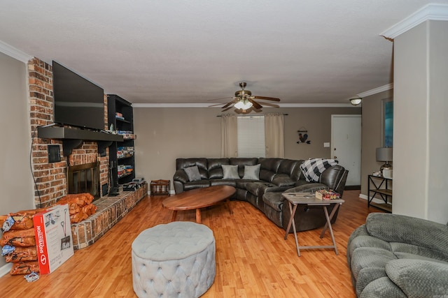 living room featuring ornamental molding, a brick fireplace, light hardwood / wood-style floors, and ceiling fan