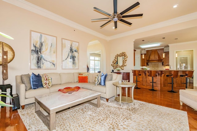 living room featuring ornamental molding, sink, wood-type flooring, and ceiling fan