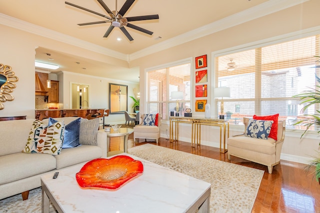 living room with light hardwood / wood-style floors, ornamental molding, and ceiling fan