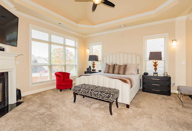 carpeted bedroom with ceiling fan, a raised ceiling, and ornamental molding