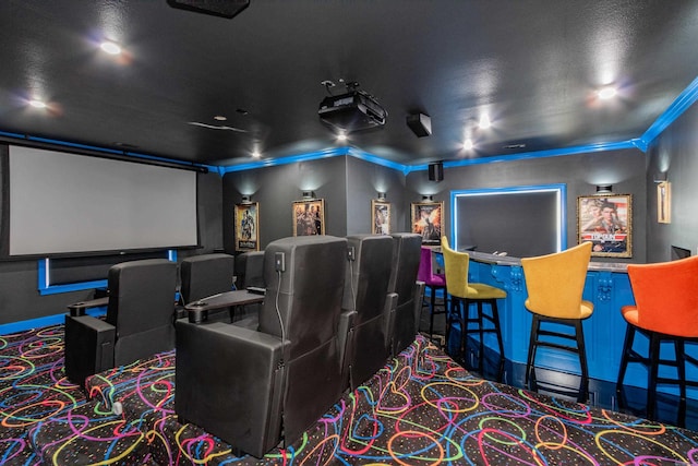 home theater room featuring ornamental molding and carpet floors