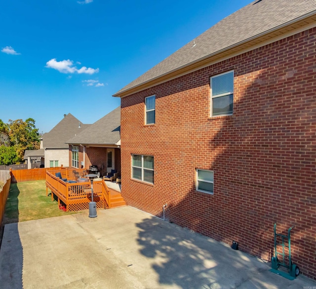 rear view of house with a patio, a deck, and a yard