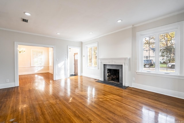 unfurnished living room with crown molding, hardwood / wood-style floors, and a tile fireplace