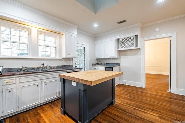 kitchen featuring white cabinetry, butcher block counters, a center island, and dark hardwood / wood-style floors