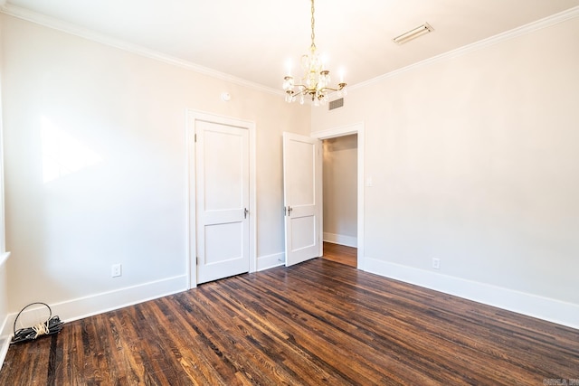 spare room featuring crown molding, a chandelier, and dark hardwood / wood-style floors