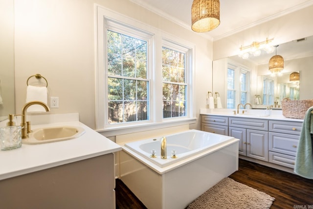 bathroom with vanity, a tub, crown molding, and wood-type flooring