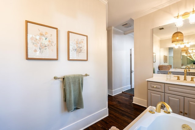 bathroom with vanity, wood-type flooring, ornamental molding, and a washtub