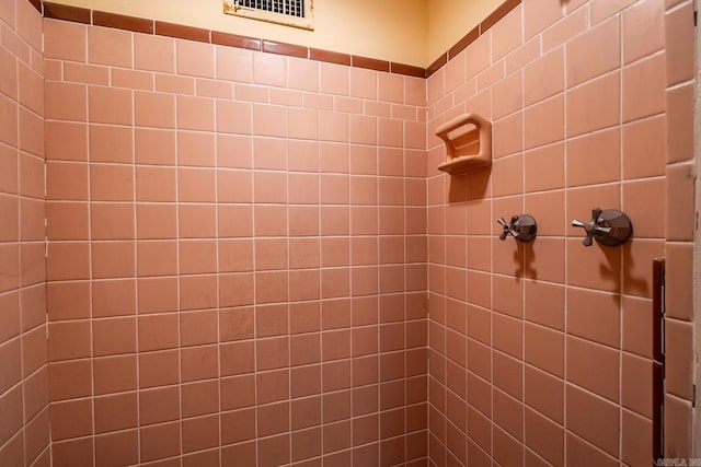 interior details featuring a tile shower