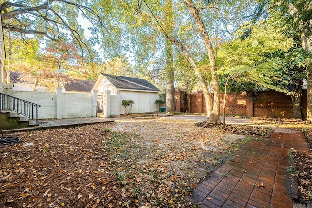 view of yard with a patio, a storage shed, and a wooden deck