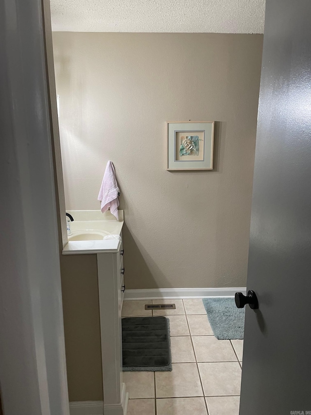 bathroom featuring vanity, a textured ceiling, and tile patterned flooring