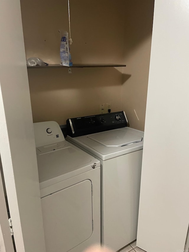 laundry room with washer and dryer and light tile patterned floors